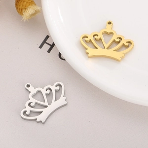 Detail of DIY crown pendants in gold and silver finish on a ceramic background