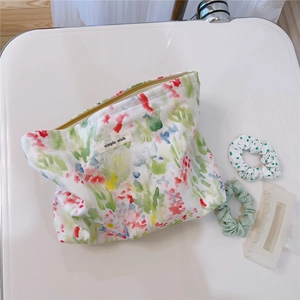 Macro view of floral print cotton makeup bag with simple wish label and hair accessories