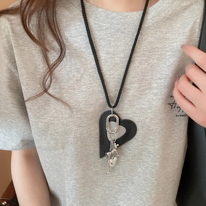 Detail of leather heart pendant with silver puppy charm on a black braided cord necklace