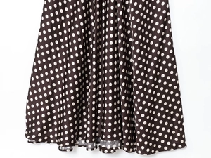 Détail de la robe à pois marron foncé montrant l'ourlet ondulé et la texture du tissu