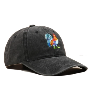 Detail shot of rooster embroidery on vintage washed cotton baseball cap with distressed texture