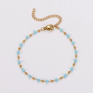 Detail of blue cubic beads and golden metal spheres on a stainless steel bracelet