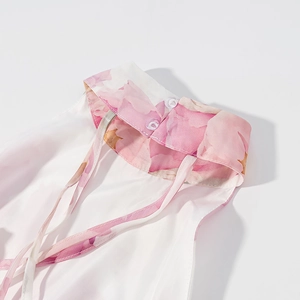 Close-up of white floral summer dress neckline with pink print and dual button closure