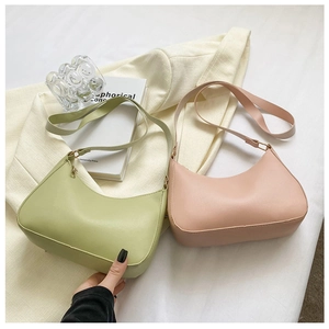 Detail view of crescent shoulder bags in pastel green and pink faux leather on a blazer