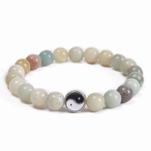 Detail of multi-color 8mm stone beads featuring a silver Yin Yang Tai Chi pendant charm