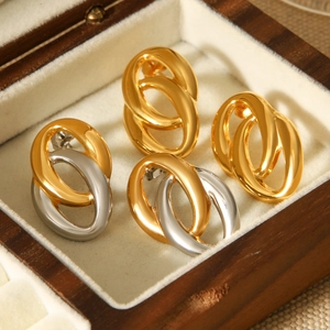 Detail of gold and silver interlocking double hoop earrings in a wooden jewelry box