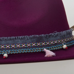 Detail of wool fedora hat featuring colorful woven band with ethnic tassels and beads