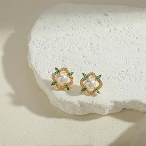 Freshwater pearl earrings with golden flower design and green marquise gems