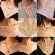 Detailed grid view of layered gold-tone necklaces with pearls and coin pendants