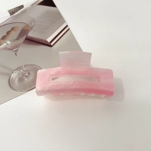 Detailed shot of pink gradient starry hair claw clip with glitter finish on table