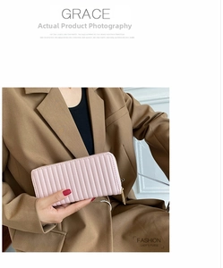 Close-up of pink long PU leather wallet with vertical quilting and gold metal zipper detail
