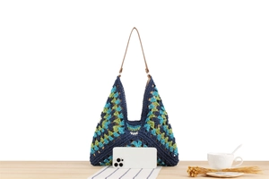 Detail of color-block woven tote bag with brown straps and interior space reference