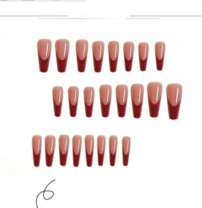 Macro detail of 24-piece long coffin press-on nails with red French tips and nude base