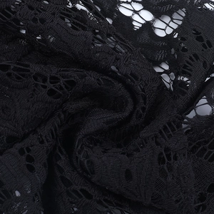 Macro shot of black lace fabric showing intricate hollow-out patterns and knitted textures