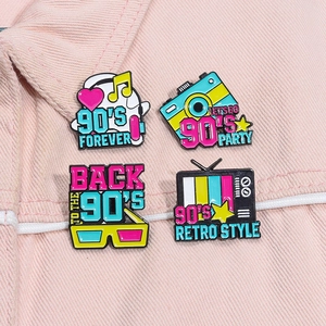 Gros plan de pin's rétro des années 90 avec caméra et télé sur une veste en jean