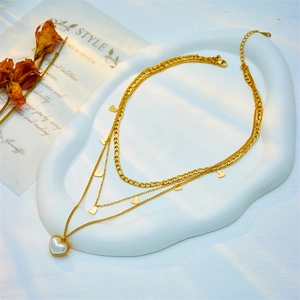 Three-layer gold titanium steel necklace featuring mother-of-pearl heart pendant and charms