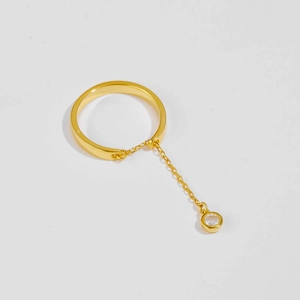 Detail of s925 silver gold-plated ring featuring a chain and white zircon pendant