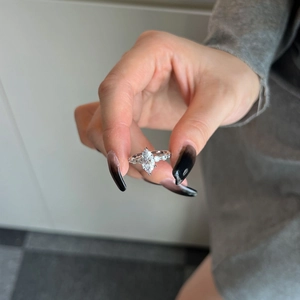 Macro shot of a 925 silver marquise-cut diamond ring held between fingers for detail