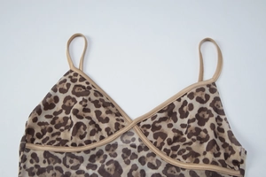 Detailed close-up of leopard print sheer mesh fabric and stitching on a V-neck camisole