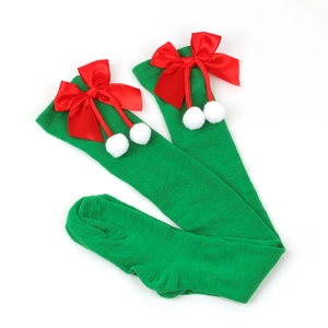 Detail of green Christmas over-knee socks with red satin bow and white fuzzy pom-poms
