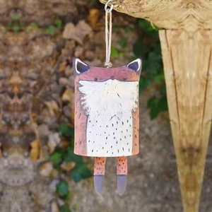 Detail of hand-painted resin fox wind chime with natural hemp rope hanging outdoors