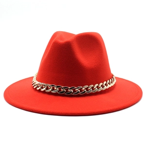 Detail of red wool felt fedora featuring a wide flat brim and a chunky gold chain band