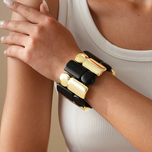 Close-up of a wide acrylic stretch bracelet with gold and black chunky resin segments