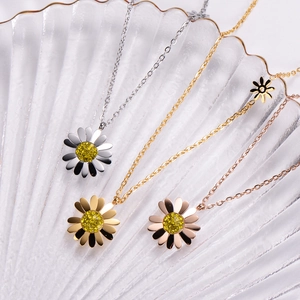 Detailed view of three daisy pendant necklaces in silver, gold, and rose gold finishes