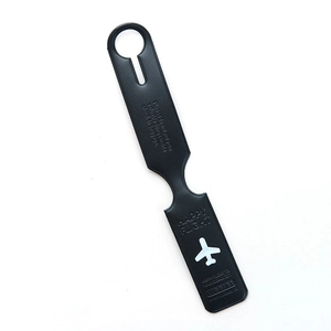 Macro detail of black faux leather luggage tag with white airplane icon on white background