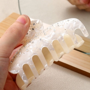 Premium pearl white acetate hair claw clip with rhinestones and marble texture detail