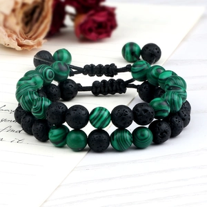 Macro detail of malachite and lava stone beads on adjustable braided bracelet