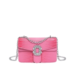 Pink croc-embossed mini square bag featuring a crystal buckle and silver chain strap