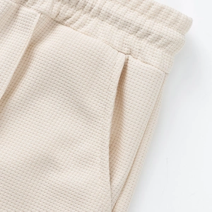 Detalle del tejido tipo gofre en pantalones cortos beige de hombre con cintura elástica