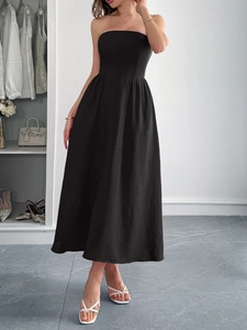 Elegant black strapless A-line maxi dress worn by model for a minimalist summer look