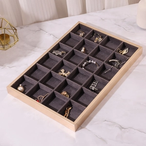 Macro detail of jewelry display tray with 24 compartments and golden metal frame