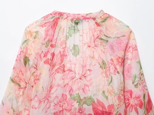 Dettaglio ravvicinato di camicia in chiffon a fiori rosa con texture del tessuto e colletto