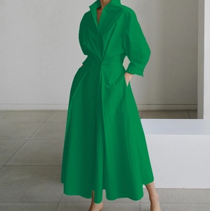 Dettaglio dell'abito lungo verde a maniche lunghe con scollo a V, vita segnata e bottoni