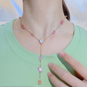 Macro shot of Y-shaped rose gold necklace with colorful zircon crystals on a model