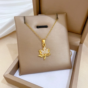 Close-up of a gold maple leaf pendant with crystals inside a premium jewelry box