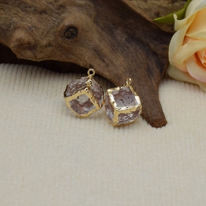 Detail of vintage square resin pendant with gold-plated frame on beige fabric