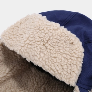 Dettaglio del cappello da aviatore in tela blu scuro con spessa fodera in pile bianco
