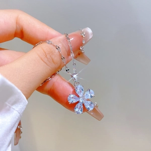 Macro shot of a five-petal flower pendant with blue crystals on a silver titanium steel chain