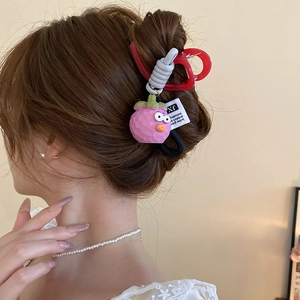 Close-up of cute cartoon mangosteen pendant and red heart hair claw clip on female hair