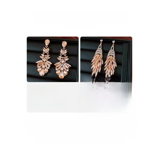 Detail showing crystal feather tassel earrings and vintage floral cluster studs