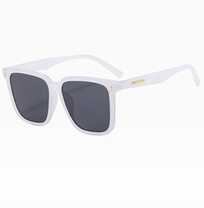 Detail view of white square sunglasses with gold metal accents and dark polarized lenses