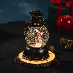 Christmas lantern snow globe with snowman and tree on wooden base with pine cones