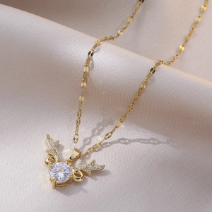 Gold titanium elk antler necklace with sparkling zircon pendant on silk background