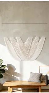 Detail of hand-woven cotton macrame tapestry with solid wood bar and bohemian arc patterns
