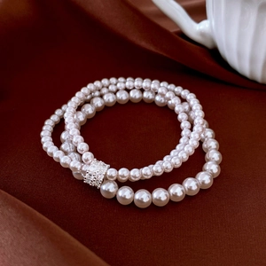 Detailed view of a triple-layer pearl bracelet with a sparkling silver rhinestone clasp