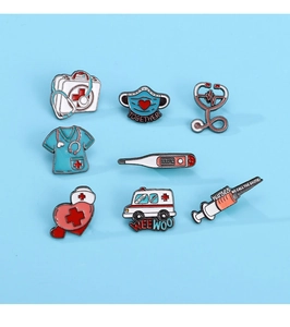Flat lay of medical enamel pins set featuring stethoscope and ambulance on blue background